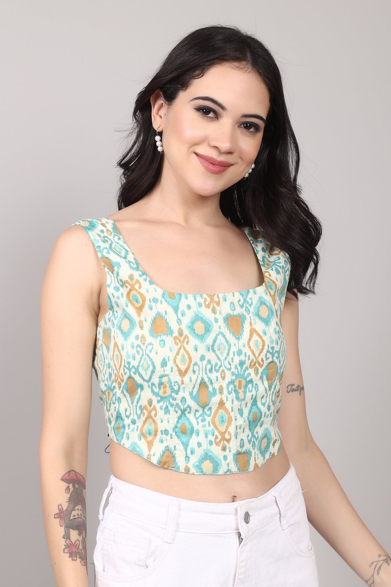Sleeveless cream corset top with aqua blue and mustard ikat print, square neckline, deep U back, and fitted waist in cotton fabric