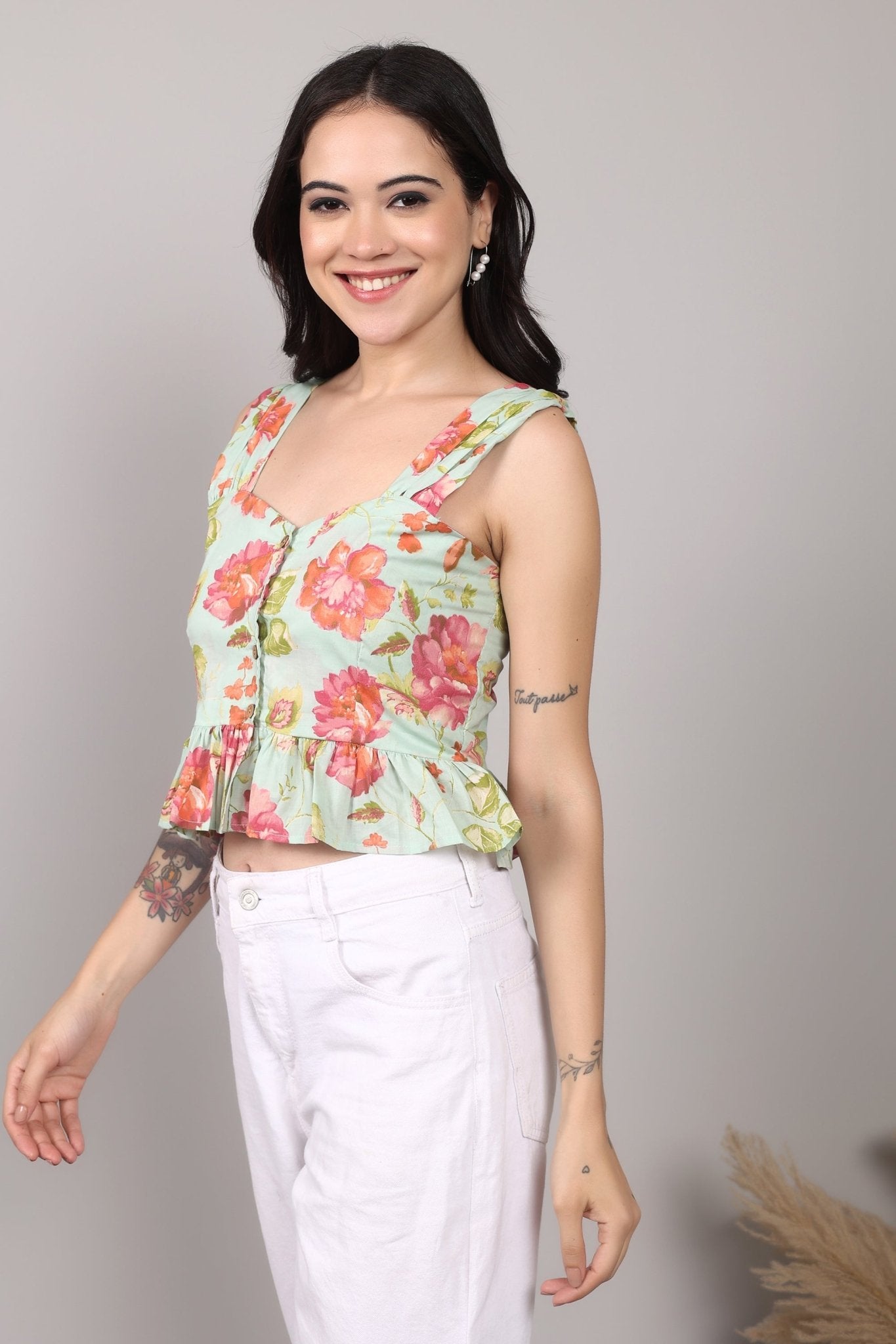 Sleeveless mint green 100% cotton peplum top with vibrant pink and orange floral print, wide straps, sweetheart neckline, button-down front, and ruffled hem