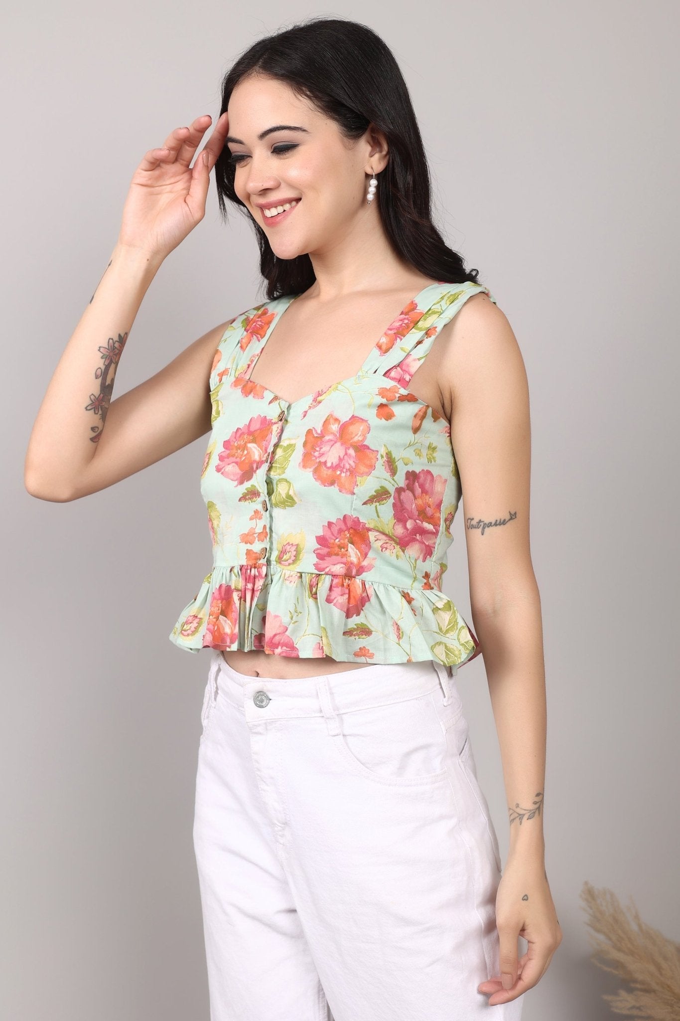 Sleeveless mint green 100% cotton peplum top with vibrant pink and orange floral print, wide straps, sweetheart neckline, button-down front, and ruffled hem