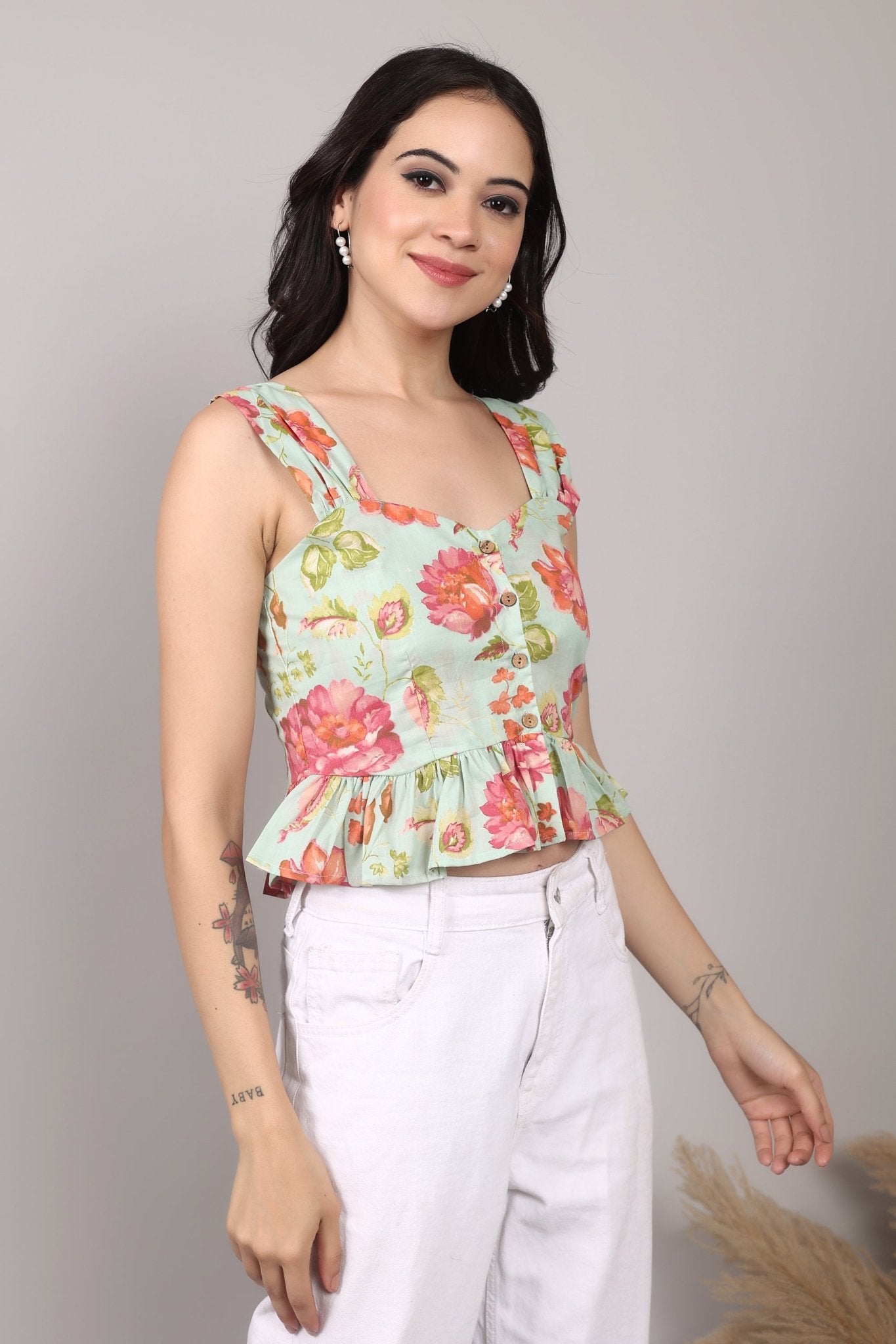 Sleeveless mint green 100% cotton peplum top with vibrant pink and orange floral print, wide straps, sweetheart neckline, button-down front, and ruffled hem