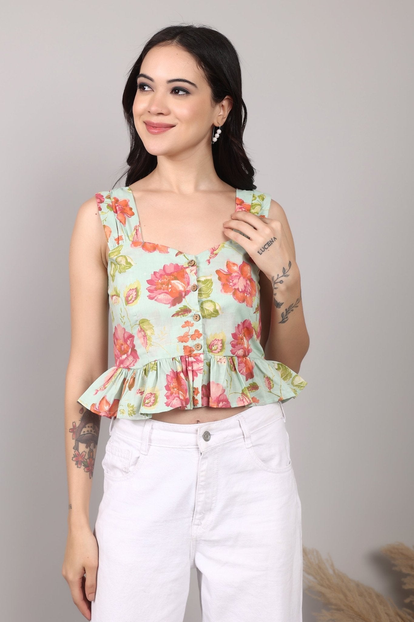 Sleeveless mint green 100% cotton peplum top with vibrant pink and orange floral print, wide straps, sweetheart neckline, button-down front, and ruffled hem