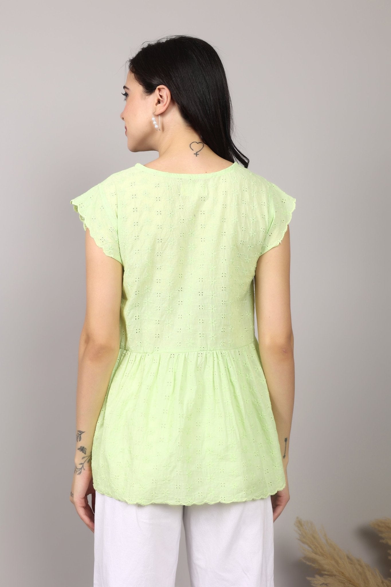 Lime green 100% Schiffli cotton wrap-style top with V-neckline, flutter cap sleeves, flared mid-hip hem, scalloped edging, relaxed fit.