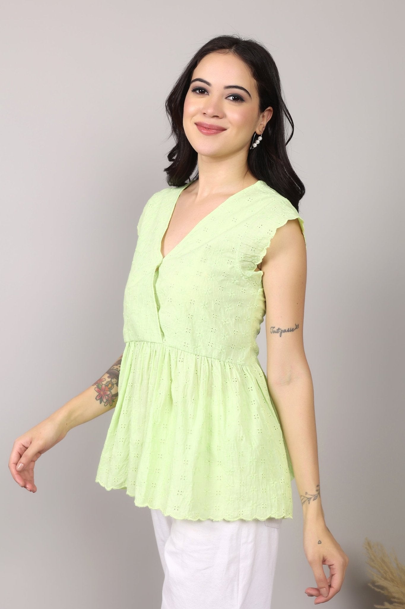 Lime green 100% Schiffli cotton wrap-style top with V-neckline, flutter cap sleeves, flared mid-hip hem, scalloped edging, relaxed fit.