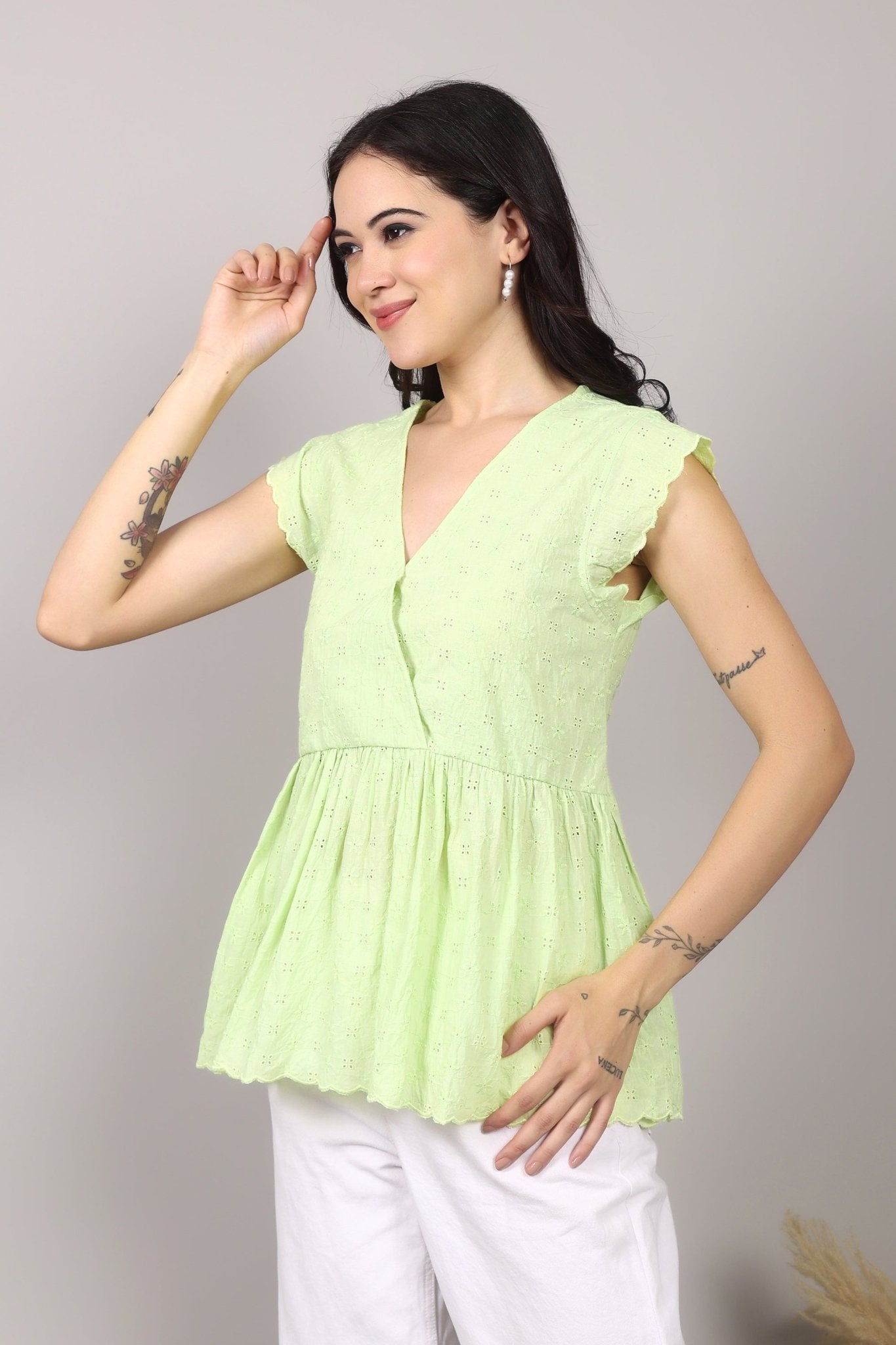 Lime green 100% Schiffli cotton wrap-style top with V-neckline, flutter cap sleeves, flared mid-hip hem, scalloped edging, relaxed fit.
