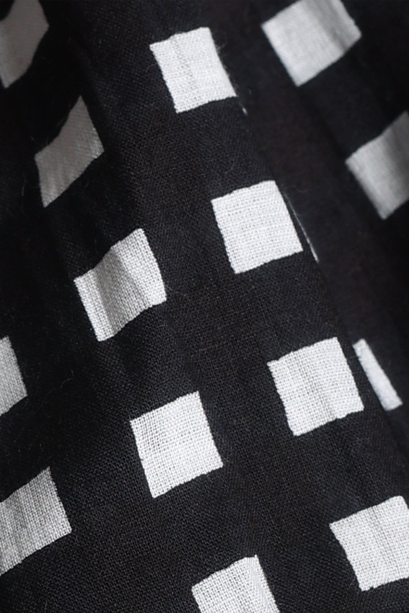 Black-and-white gingham cotton midi dress with square neckline, ruffled cap sleeves, fit-and-flare silhouette, tiered skirt, and a fixed bow at the back.