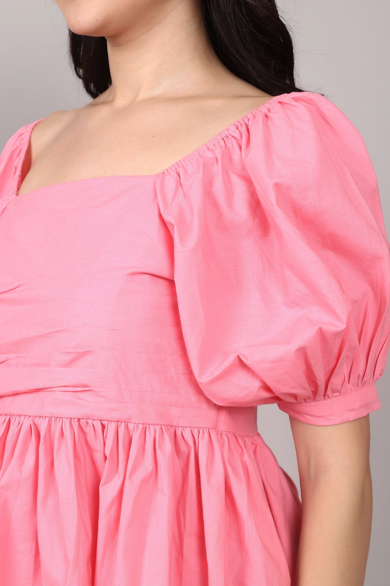Soft pink 100% cotton peplum top with exaggerated puff sleeves, square neckline, gathered bust detailing, and a breezy relaxed fit for an effortlessly feminine look.