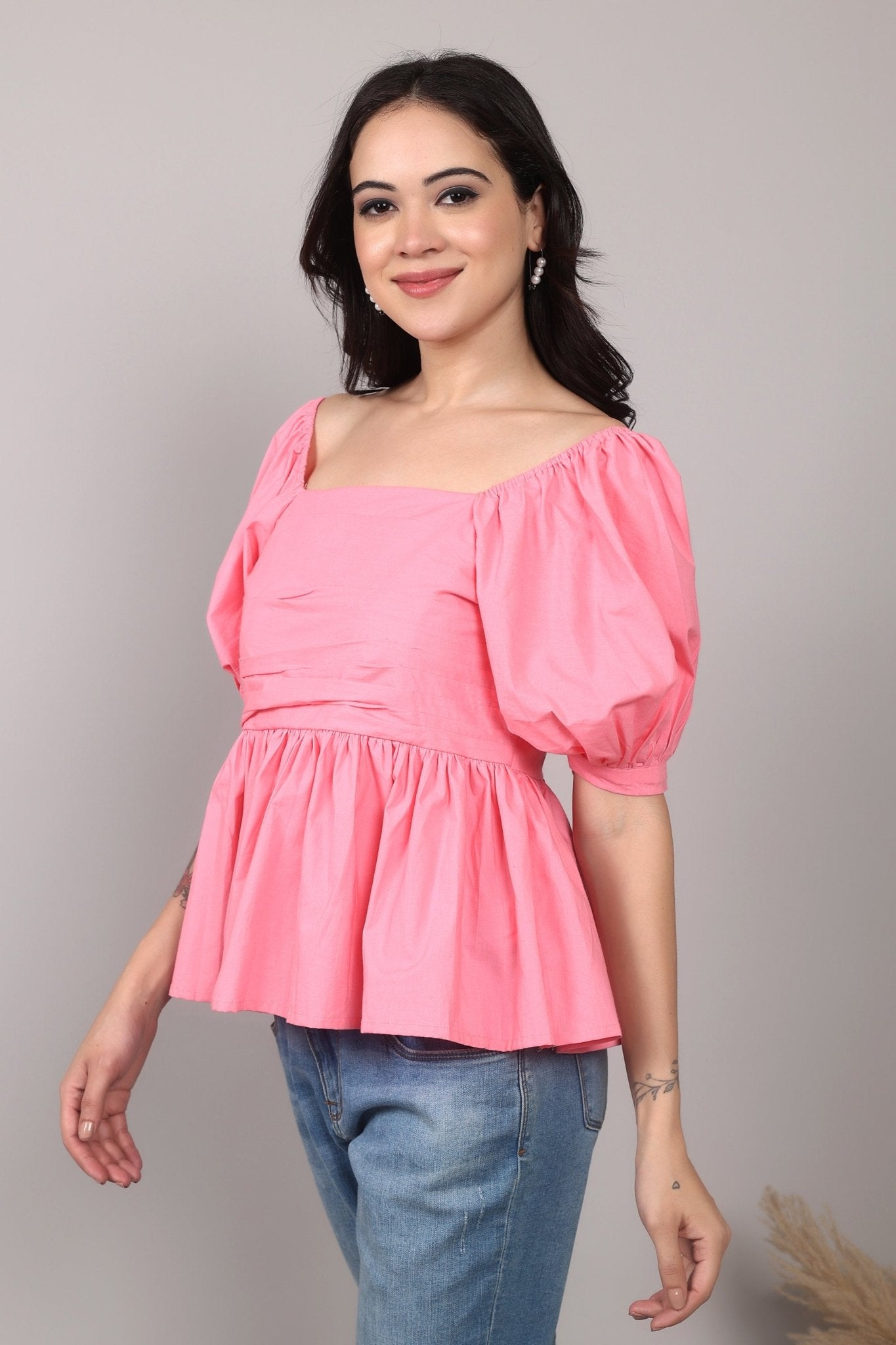 Soft pink 100% cotton peplum top with exaggerated puff sleeves, square neckline, gathered bust detailing, and a breezy relaxed fit for an effortlessly feminine look.