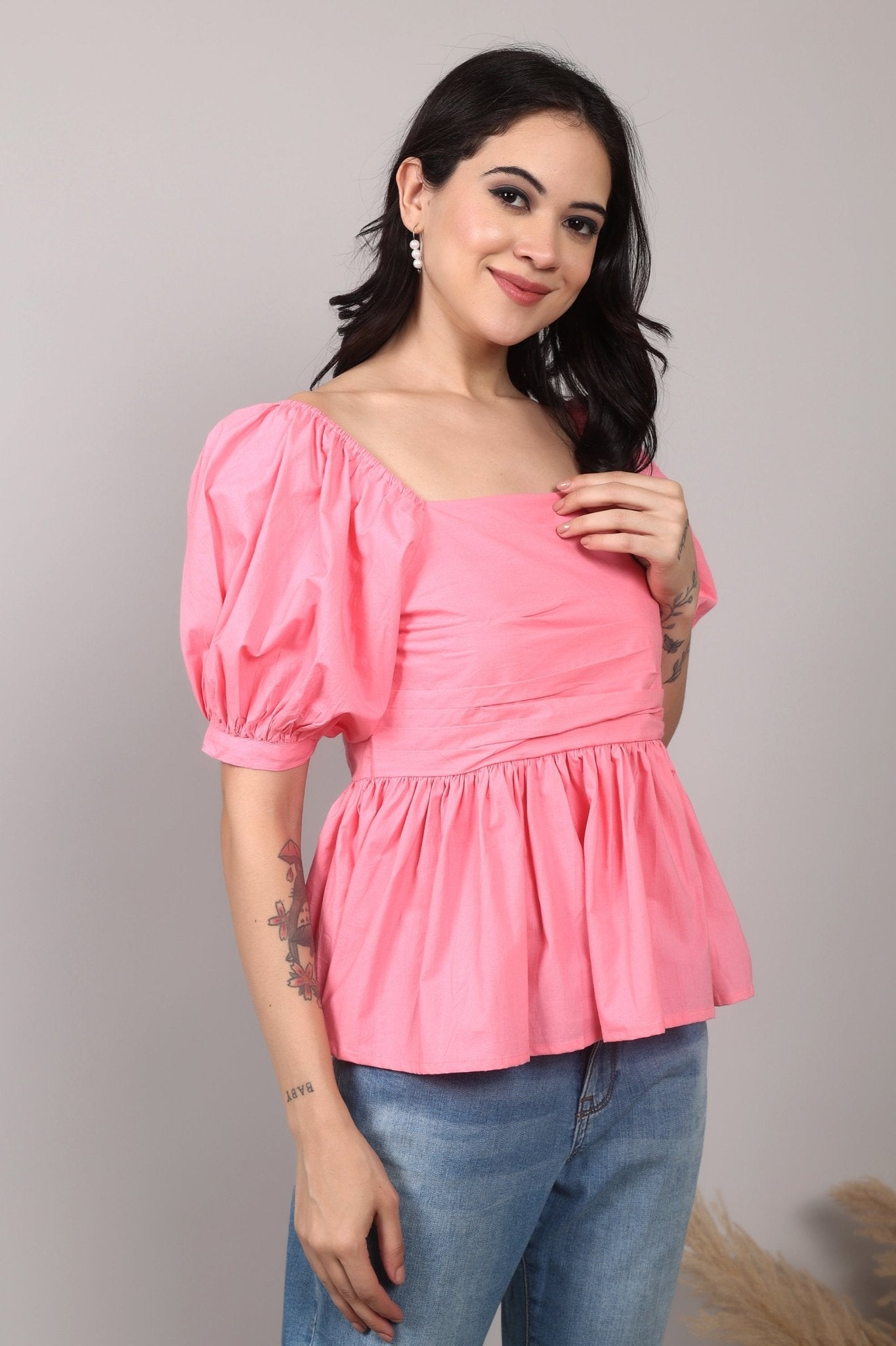 Soft pink 100% cotton peplum top with exaggerated puff sleeves, square neckline, gathered bust detailing, and a breezy relaxed fit for an effortlessly feminine look.