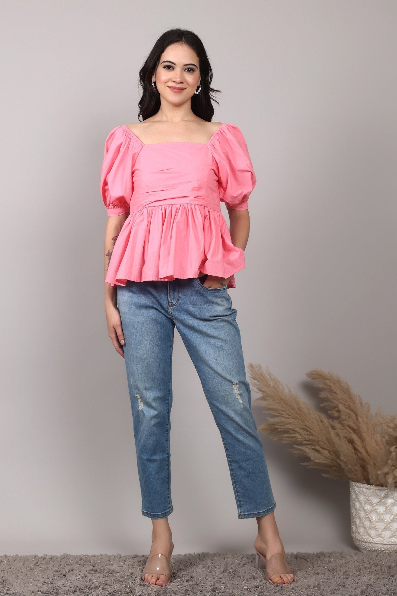 Soft pink 100% cotton peplum top with exaggerated puff sleeves, square neckline, gathered bust detailing, and a breezy relaxed fit for an effortlessly feminine look.