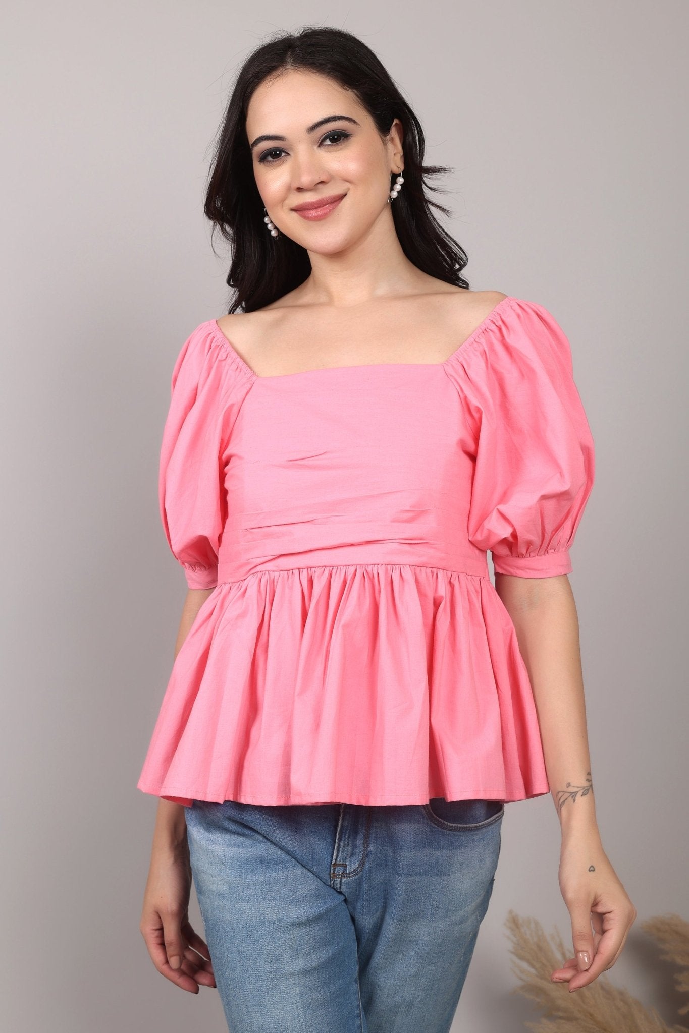 Soft pink 100% cotton peplum top with exaggerated puff sleeves, square neckline, gathered bust detailing, and a breezy relaxed fit for an effortlessly feminine look.
