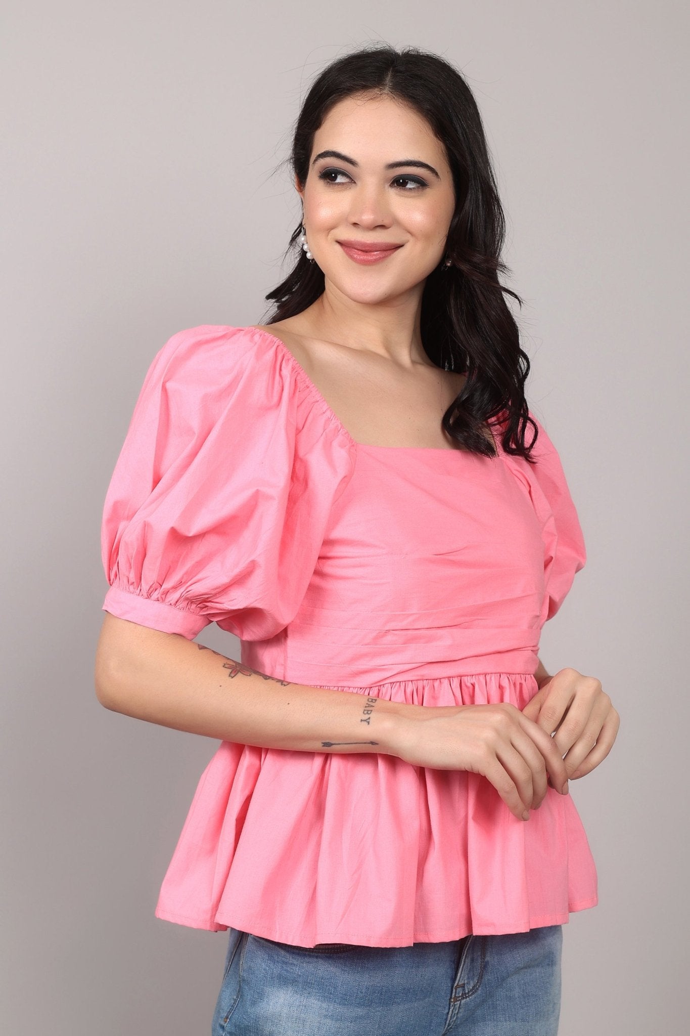 Soft pink 100% cotton peplum top with exaggerated puff sleeves, square neckline, gathered bust detailing, and a breezy relaxed fit for an effortlessly feminine look.