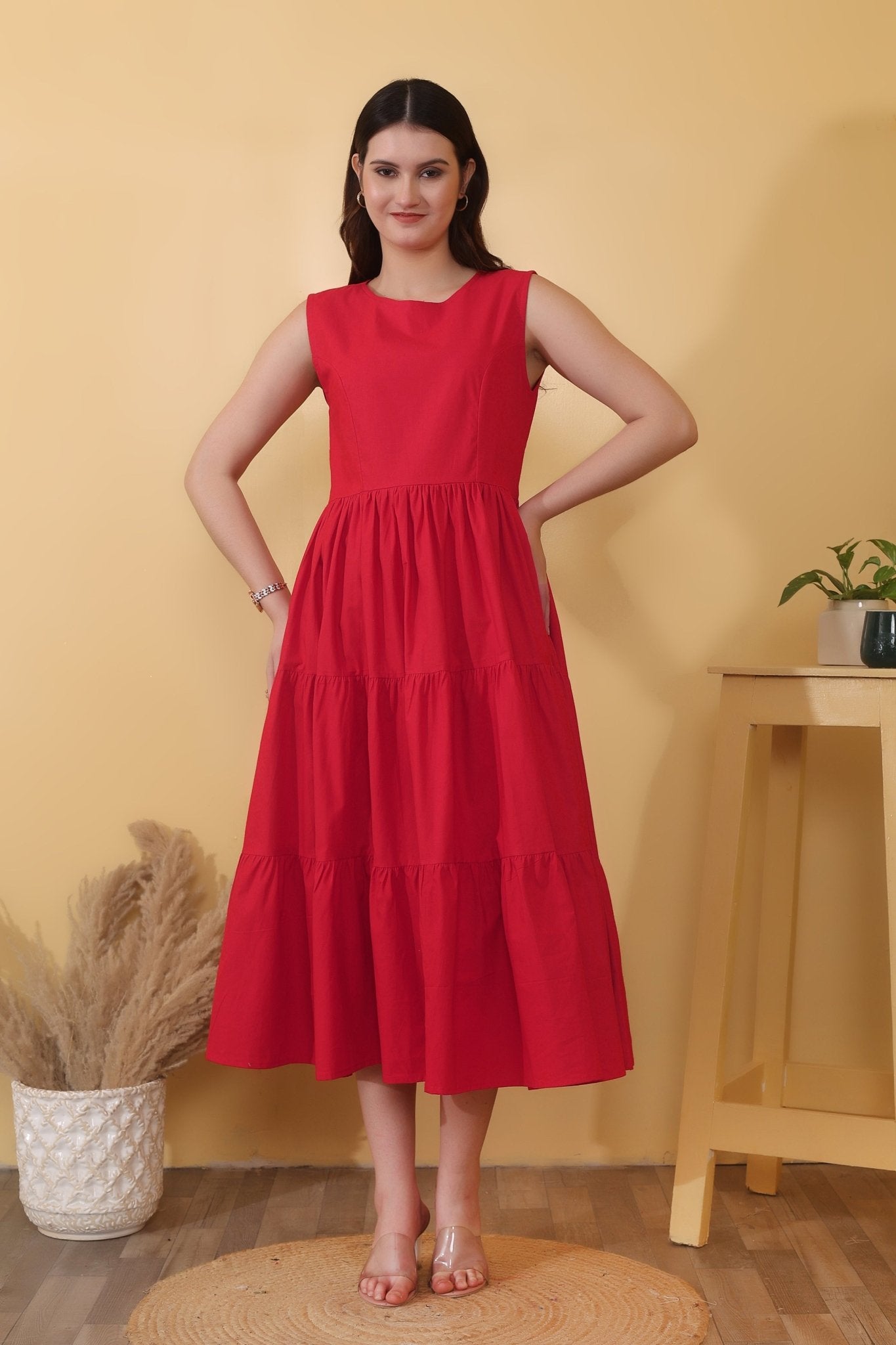 Bold red cotton poplin dress with sleeveless fit-and-flare shape, tiered hem, and a dramatic open back detailed with a tie-up bow closure.