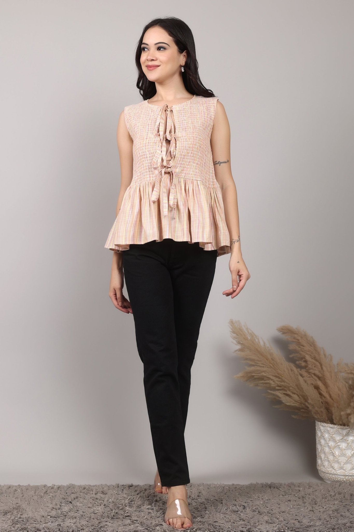 Beige sleeveless cotton-blend top with multicolor striped weave, smocked bodice, triple-tie front keyhole, and flared peplum hem—relaxed and breezy.