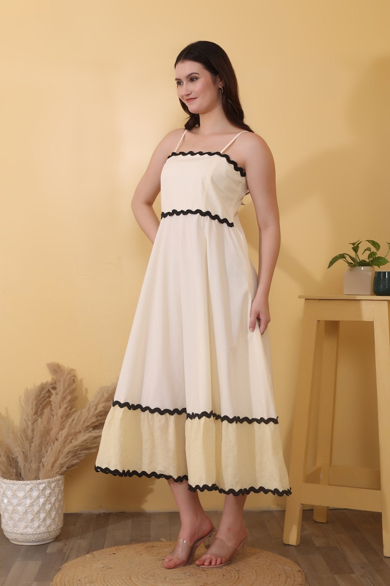 Vanilla Daze - Cream maxi dress crafted from 100% cotton poplin with Schiffli cotton tiers, featuring a straight neckline with adjustable spaghetti straps, smocked back, tiered hem, and bold black ric-rac trim.
