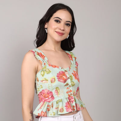 Insaneful floral peplum top in pastel green with red-pink blooms, styled with white high-waist pants – chic summer look for casual brunches.