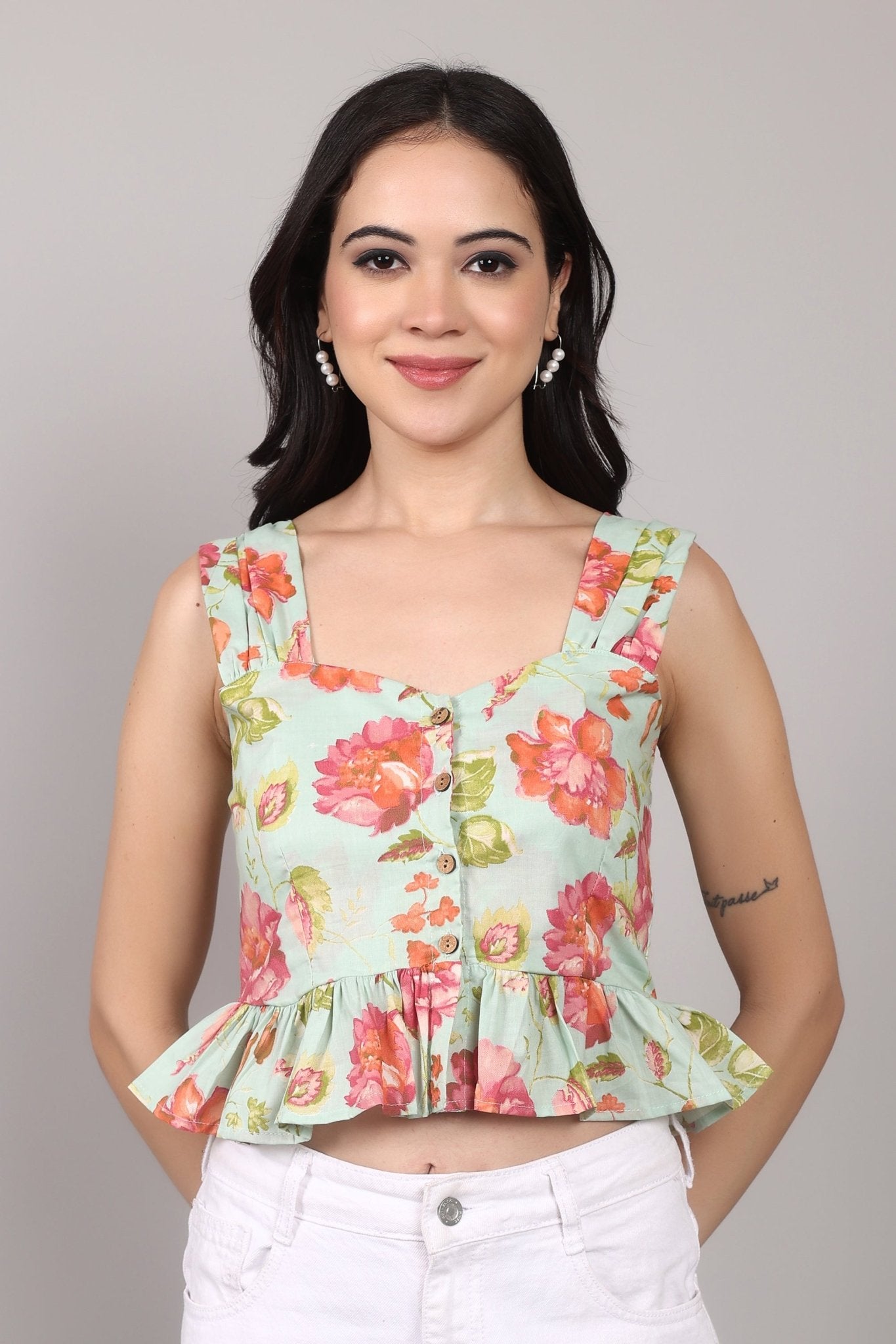 Sleeveless mint green 100% cotton peplum top with vibrant pink and orange floral print, wide straps, sweetheart neckline, button-down front, and ruffled hem